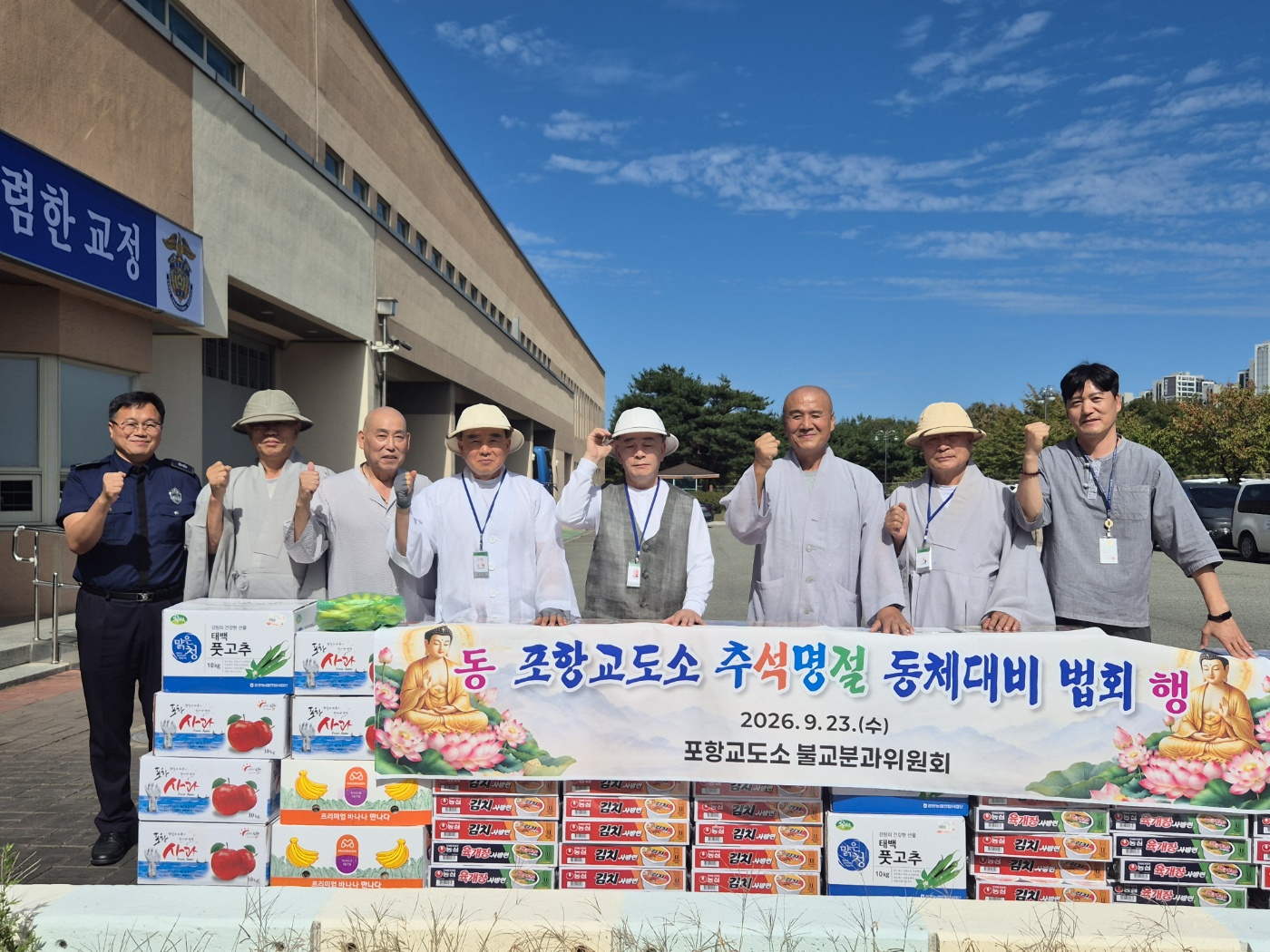 포항교도소 앞 위문품과 현수막 앞에서 주먹을 쥐고 함께한 스님들과 교도관