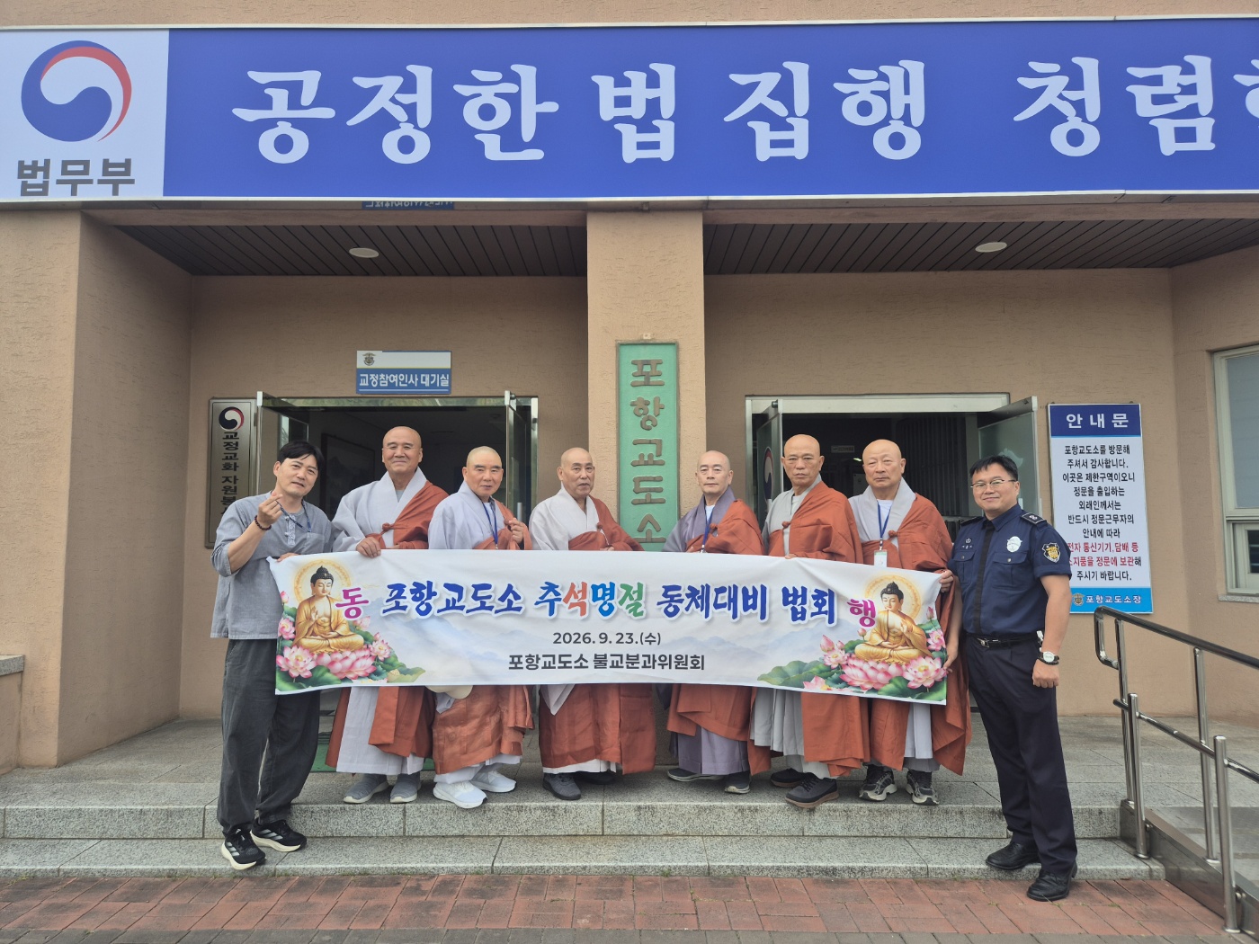 포항교도소 현관 앞에서 동체대비 법회 현수막을 펼쳐 든 스님들과 관계자들